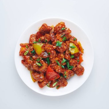 Mançurya tavuğu beyaz arka planda izole edilmiş. Mançurya usulü tavuk göğsü, dolmalık biber, domates ve soya soslu Hint yemeği. İzole et