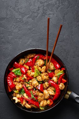 Schezwan Tavuğu ya da Ejderha Tavuğu siyah arkaplanda. Szechuan tavuğu popüler Hint-Çin baharatlı baharatlı biber, tavuk ve sebzedir..