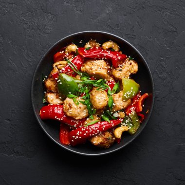 Schezwan tavuğu ya da Dragon tavuğu siyah kasede, arka planda. Szechuan tavuğu popüler Hint-Çin baharatlı baharatlı biber, tavuk ve sebzedir..