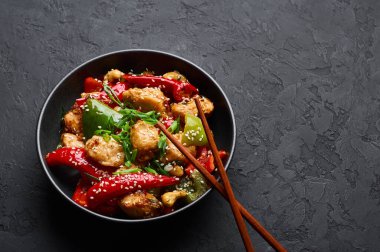 Schezwan tavuğu ya da Dragon tavuğu siyah kasede, arka planda. Szechuan tavuğu popüler Hint-Çin baharatlı baharatlı biber, tavuk ve sebzedir..