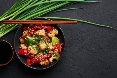 Schezwan tavuğu ya da Dragon tavuğu siyah kasede, arka planda. Szechuan tavuğu popüler Hint-Çin baharatlı baharatlı biber, tavuk ve sebzedir..