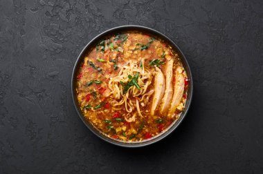 Siyah kasede, arka planda Manchow Çorbası. Manchow çorbası Çin mutfağında dolma biber, lahana, havuç, erişte, kırmızı biber, soya sosu, soğan, tavuk göğsü....