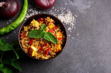 Siyah arka planda vejetaryen paneer biryani. Paneer biryani, paneer peyniri, basmati pilavı, masala, acı biber, nane ve daha birçok baharatla geleneksel Hint mutfağı. Boşluğu kopyala