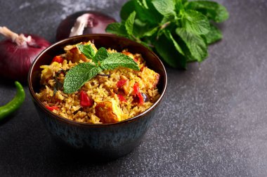 Siyah arka planda vejetaryen paneer biryani. Paneer biryani, paneer peyniri, basmati pilavı, masala, acı biber, nane ve daha birçok baharatla geleneksel Hint mutfağı. Boşluğu kopyala