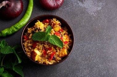 Siyah arka planda vejetaryen paneer biryani. Paneer biryani, paneer peyniri, basmati pilavı, masala, acı biber, nane ve daha birçok baharatla geleneksel Hint mutfağı. Boşluğu kopyala