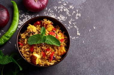 Siyah arka planda vejetaryen paneer biryani. Paneer biryani, paneer peyniri, basmati pilavı, masala, acı biber, nane ve daha birçok baharatla geleneksel Hint mutfağı. Boşluğu kopyala