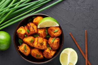 Paneer Mançurya ya da Paneer 65, siyah beton arka planda kasede. Paneer Mançurya, Çin mutfağında panner peyniri, domates, soğan ve soya sosu ile servis edilir. Boşluğu kopyala