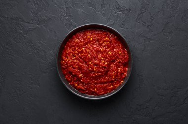 Schezwan sosu siyah kasede, arka planda. Schezwan Sosu Hint-Çin ya da Sichuan mutfağından kırmızı biberli, sarımsaklı ve zencefilli acı sos..