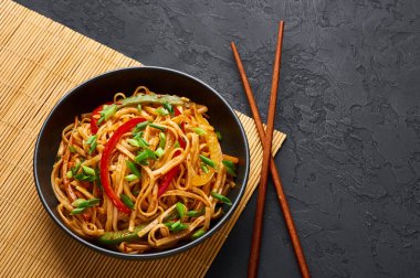 Vejetaryen Schezwan Eriştesi ya da Sebze Hakka Eriştesi ya da siyah arka planda Chow Mein. Hint-Çin mutfağı, udon eriştesi, sebze ve biber soslu sıcak yemek. Boşluğu kopyala
