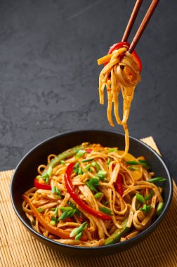 Vejetaryen Schezwan Eriştesi ya da Sebze Hakka Eriştesi ya da siyah arka planda Chow Mein. Schezwan Eriştesi Hint-Çin mutfağı. Erişte, sebze ve biber soslu sıcak yemek.