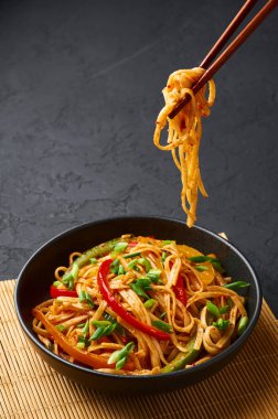 Vejetaryen Schezwan Eriştesi ya da Sebze Hakka Eriştesi ya da siyah arka planda Chow Mein. Schezwan Eriştesi Hint-Çin mutfağı. Erişte, sebze ve biber soslu sıcak yemek.