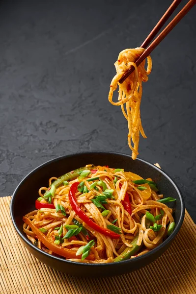 Vejetaryen Schezwan Eriştesi ya da Sebze Hakka Eriştesi ya da siyah arka planda Chow Mein. Schezwan Eriştesi Hint-Çin mutfağı. Erişte, sebze ve biber soslu sıcak yemek.