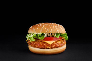 Mükemmel hamburgerli, peynirli, domatesli, siyah arka planda marullu. Boşluğu kopyala