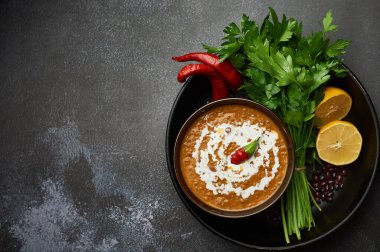Dal Makhani karanlık arka planda. Dal Makhani - Hint mutfağının geleneksel püre tabağı yanında fasulye, kırmızı fasulye, tereyağı, baharat ve krema. Boşluğu Kopyala