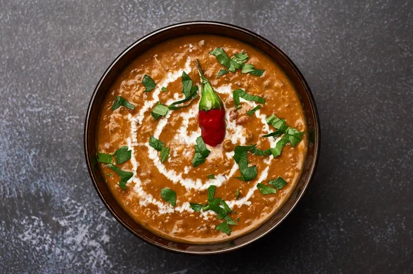 Dal Makhani karanlık arka planda. Dal Makhani - Hint mutfağının geleneksel püre tabağı yanında fasulye, kırmızı fasulye, tereyağı, baharat ve krema.