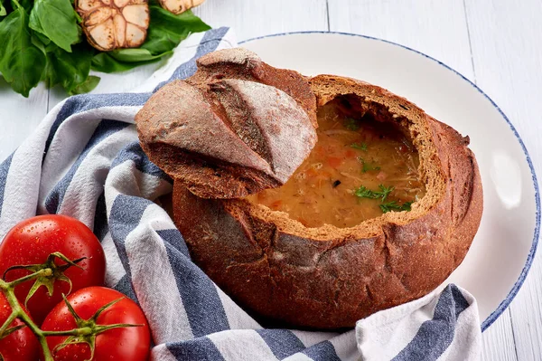 Beyaz ahşap masa üstünde ekmek kasesi çorbası. Ekmek Çorbası geleneksel Çek mutfağıdır..