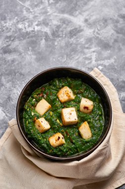 Palak Paneer gri beton arka planda. Palak paneer ya da yeşil paneer, ıspanak ve paneer peynirinin Hint mutfağından yapılan bir yemektir. Boşluğu kopyala