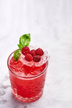 red raspberry cocktail with green mint leaf in rocks glass. Delicious Summer cocktail concept. Fresh summer drinks. Copy space. Vertical.