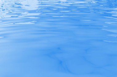 ultraviolet water of pool or sea with waves and sunlight glares at surface. abstract background
