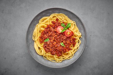Beton arka planda gri kasede spagetti bolonez. Bolonez sosu klasik İtalyan mutfağıdır. Popüler