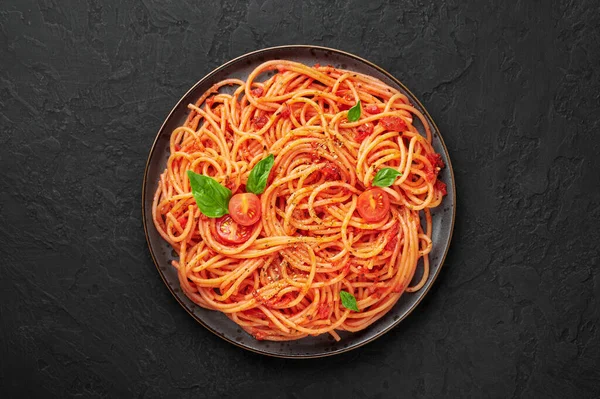 Siyah tabakta, siyah tahtada domates spagettisi. Domates soslu makarna klasik İtalyan mutfağıdır. Popüler İtalyan yemekleri. Üst görünüm