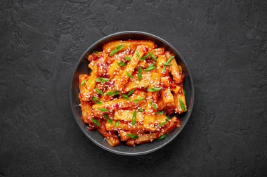 Bal biberli patates ya da Schezwan Aloo siyah kasede, masa üstünde. Kırmızı biberli patates Hint-Çin mutfağıdır. Otantik Asya yemekleri. Hint yemeği. Üst görünüm