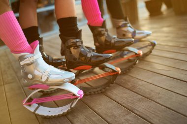 Kangoo botlu bir grup kadın bacağı. Grupta açık hava fitness antrenmanı