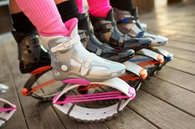 Kangoo botlu bir grup kadın bacağı. Grupta açık hava fitness antrenmanı
