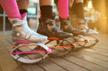 Kangoo botlu bir grup kadın bacağı. Grupta açık hava fitness antrenmanı