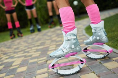 Kangoo botlu bir grup kadın bacağı. Grupta açık hava fitness antrenmanı