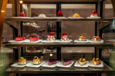 Manu küçük renkli kekler vitrinde satışta.