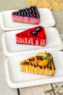 Kayısı eriği ve ahşap kırsal masada frenk üzümü olan üç üçgen kek.