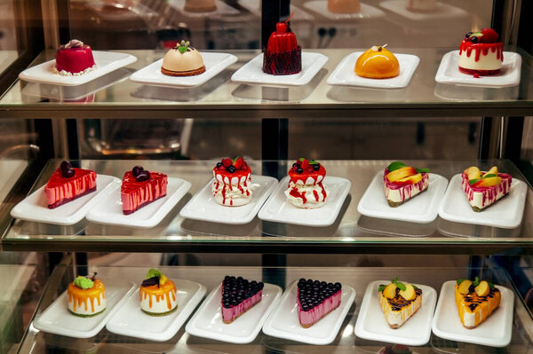 Маленькие красочные торты ману за витриной в магазине уже в продаже