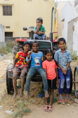 group of poor indian kids sits on tractor in outdoors 11 february 2018 Puttaparthi, India