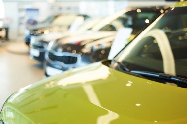 modern car showroom. blurred automobile hoods. not in focus background. copy space