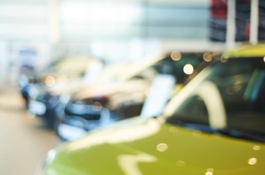 modern car showroom. blurred automobile hoods. not in focus background. copy space