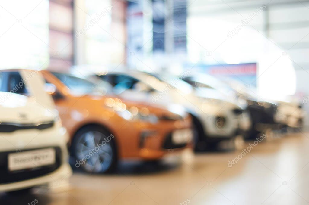 modern car showroom. blurred automobile hoods. not in focus background. copy space