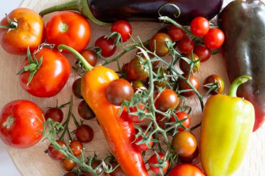 Masada duran olgun sebzelerin üst görüntüsü: domates, biber, patlıcan.