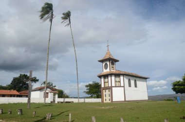 Capela do Rosario (Rosary Şapeli) Milho Verde / MG 'de güneşli bir günde yeşil çimenler ve mavi gökyüzü ile