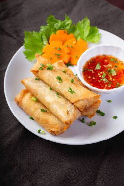 Kızarmış börek, beyaz tabak ve baharatlı sos.