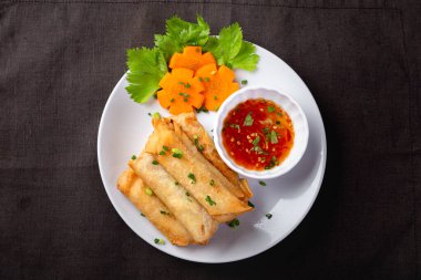 Kızarmış börek, beyaz tabak ve baharatlı sos.