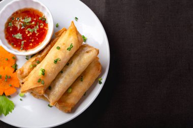 Kızarmış börek, beyaz tabak ve baharatlı sos.