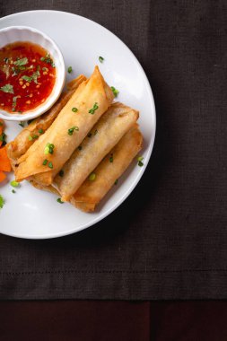 Kızarmış börek, beyaz tabak ve baharatlı sos.