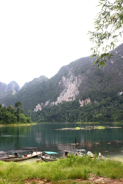霧深い山と反射湖の抽象的な背景と川沿いに係留長い尾のボートのグループのコピースペース アドベンチャー 休暇のコンセプト — ストック写真