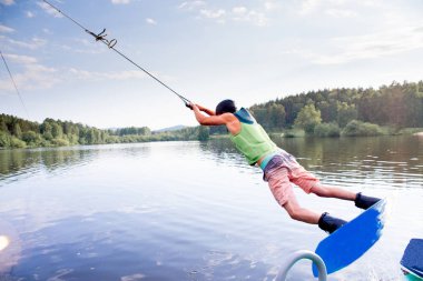 Genç adam bir gölde wakeboard sürme