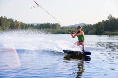 Genç adam bir gölde wakeboard sürme