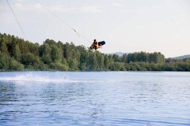 Genç adam bir gölde wakeboard sürme