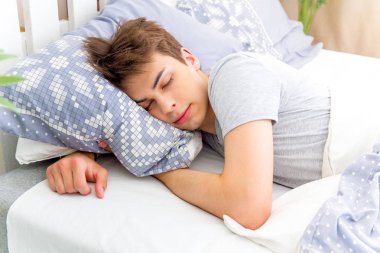 Beyaz odada uyuyan yakışıklı genç