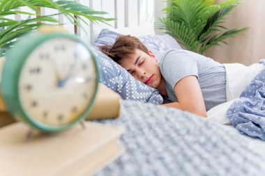 Beyaz odada uyuyan yakışıklı genç