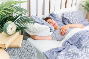 Beyaz odada uyuyan yakışıklı genç